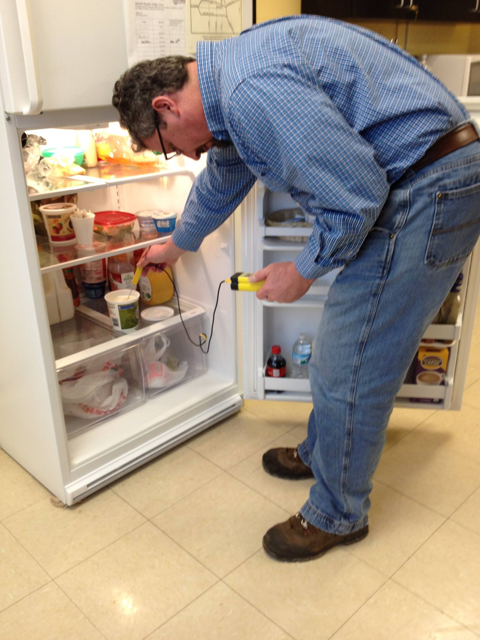 Photo of someone checking a Refrigerator's Temperature 
